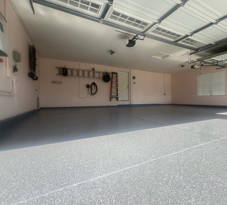 Empty modern garage interior with polished gray epoxy floor, pale pink walls, and overhead solar panel ceiling